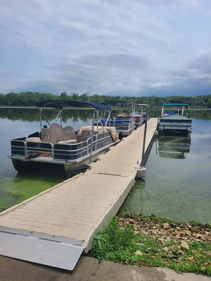 Several of Schafer's Rental pontoons are lined up on either side of a dock on beautiful Lake Onalaska.