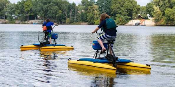 Two people peddling on hydro bikes in a big body of water. Supplied by Island Outdoors in La Crosse, this group enjoys the scenic view in a whole new way.