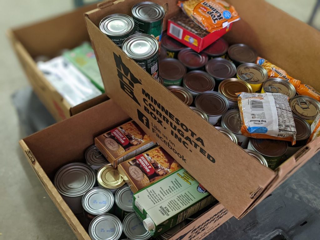 Food Drive Fridays La Crosse Cardboard boxes filled with canned goods, boxed pasta, and other non-perishable food items collected for a food drive.