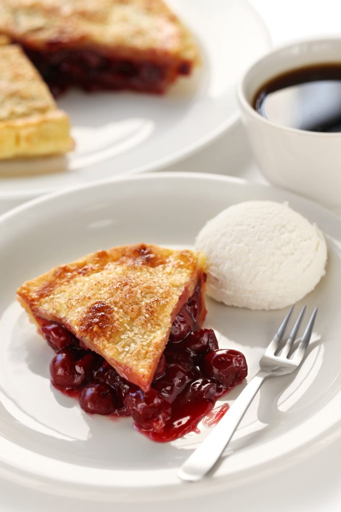 Slice of homemade cherry pie on a white plate