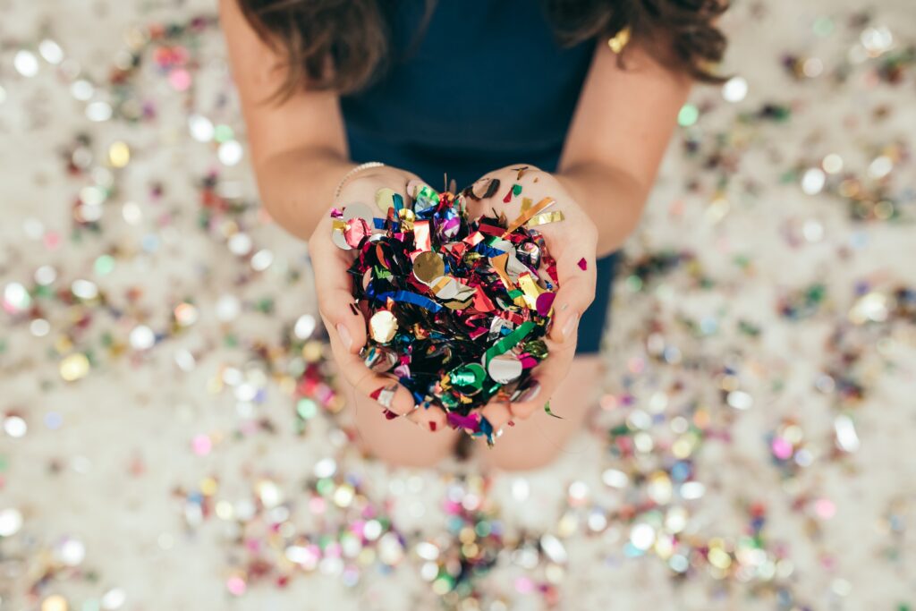 Hands holding colorful confetti during a family-friendly New Year’s Eve events in La Crosse
